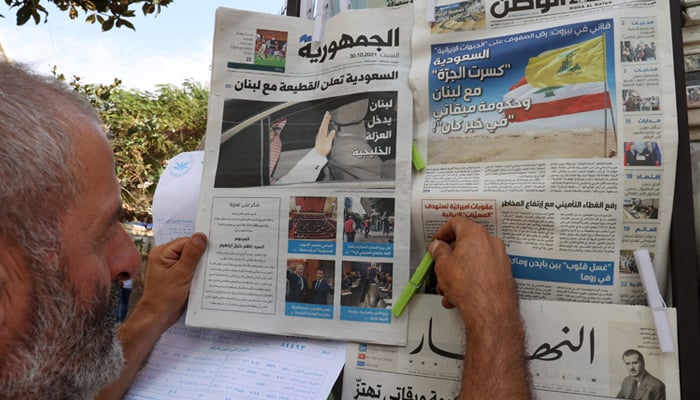 A newspaper vendor arranges newspapers, bearing headlines of the diplomatic row with Saudi Arabia, at his stall in the Lebanese capital Beirut on October 30, 2021. — AFP
