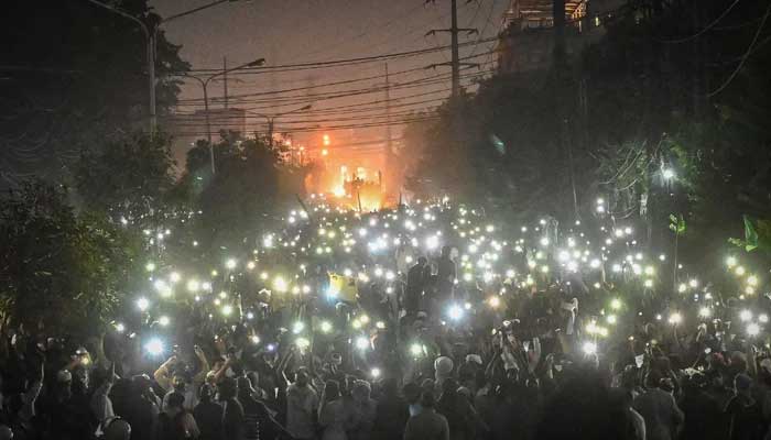 Supporters of proscribed Tehreek-e-Labbaik Pakistan(TLP) party use mobile phone flashlight during a protest march towards capital Islamabad from Lahore on October 22, 2021. Photo: AFP