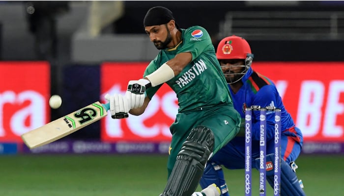 Pakistans Shoaib Malik (L) plays a shot as Afghanistans wicketkeeper Mohammad Shahzad watches during the ICC Twenty20 World Cup cricket match between Afghanistan and Pakistan at the Dubai International Cricket Stadium in Dubai on October 29, 2021. — AFP/File