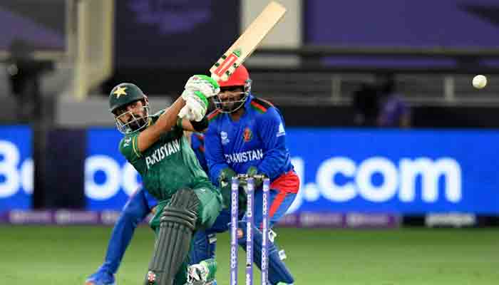 Pakistans captain Babar Azam (L) plays a shot as Afghanistan´s wicketkeeper Mohammad Shahzad watches during the ICC Mens Twenty20 World Cup cricket match between Afghanistan and Pakistan at the Dubai International Cricket Stadium in Dubai on October 29, 2021. -AFP