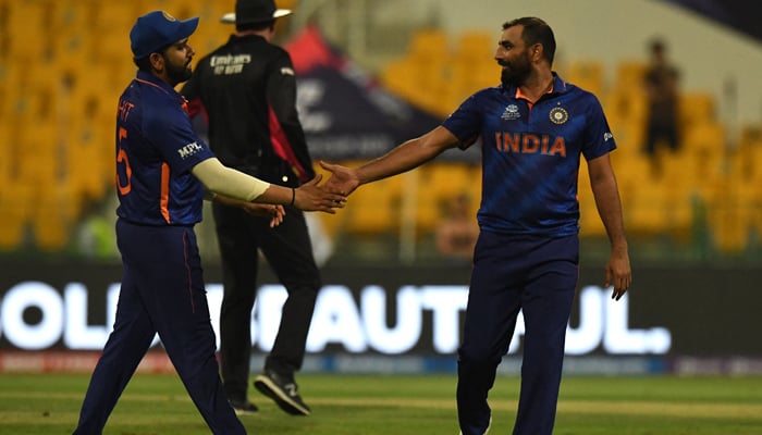 India´s Rohit Sharma (L) congratulates his teammate Mohammed Shami after he took the wicket of Afghanistan´s captain Mohammad Nabi (not pictured) during the ICC Twenty20 World Cup cricket match between India and Afghanistan at the Sheikh Zayed Cricket Stadium in Abu Dhabi on November 3, 2021. — AFP