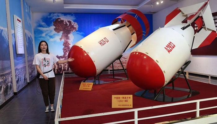 A guide explains the models of Chinas first atomic bomb (R) and hydrogen bomb (L) at an exhibition hall in Zitong County of Mianyang. Photo: Xinhua/Liu Kun