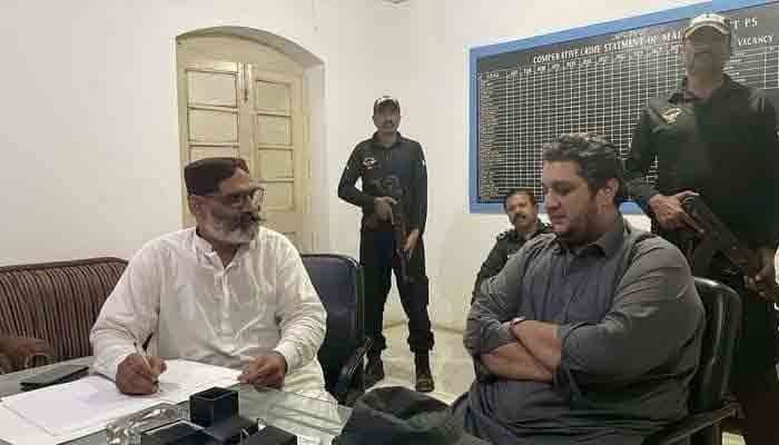 Suspect PPP MPA Jam Owais (R) seen at a police station. Photo: Twitter/@Xadeejournalist