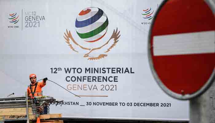 A worker removes fences next to the entrance of the World Trade Organization (WTO) headquarters on November 27, 2021 in Geneva after next week´s WTO ministerial conference, the global trade body´s biggest gathering in four years, was postponed at the last minute due to the new Omicron Covid-19 variant. -AFP