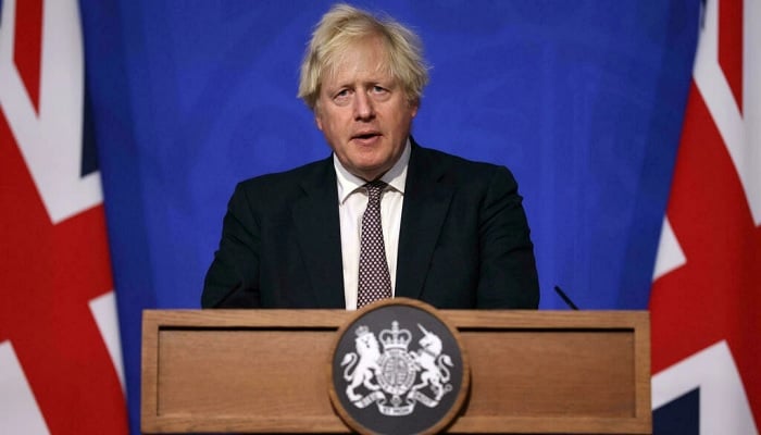Prime Minister Boris Johnson announces tougher rules in a bid to curb the spread of a new variant of Covid-19. Photo: AFP