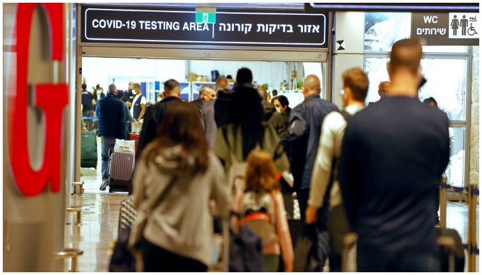 Passengers walk with their luggage upon their arrival at Israel’s Ben Gurion airport. — AFP