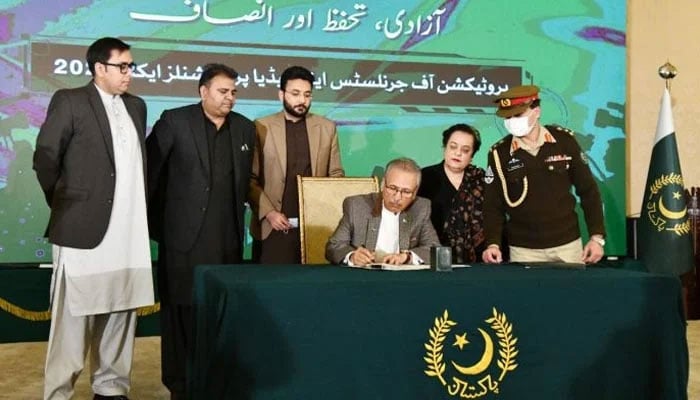 President Dr Arif Alvi signing the Protection of Journalists and Media Professionals Bill-2021 into law at Aiwan-e-Sadr in Islamabad on December 1, 2021. — APP
