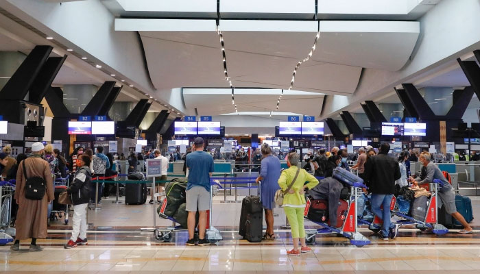 Travellers queue at a check-in counter at OR Tambo International Airport in Johannesburg after several countries banned flights from South Africa. AFP
