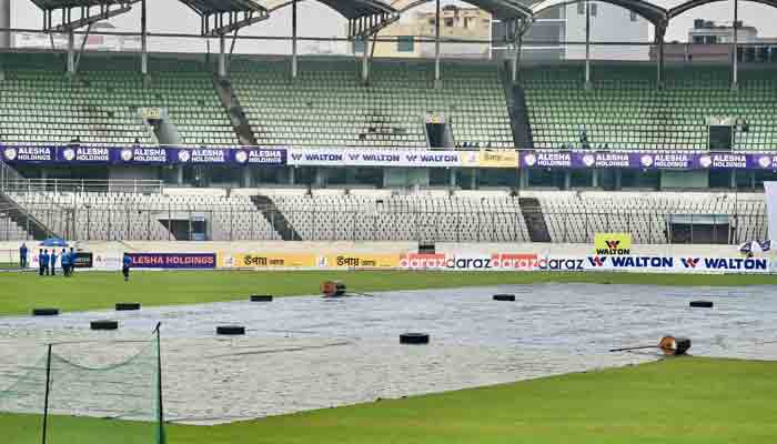 Groundstaff covers the field as it starts to rain on the second day of the second Test cricket match between Bangladesh and Pakistan at the Sher-e-Bangla National Cricket Stadium in Dhaka on December 5, 2021.-AFP