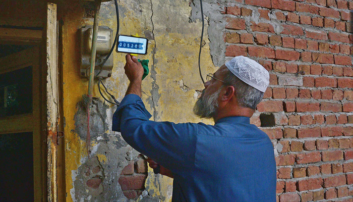 A WAPDA employee conducting a meter reading at Kacheri Bazaar in Faisalabad, November 15, 2021. — Online photo by Haji Ibrahim
