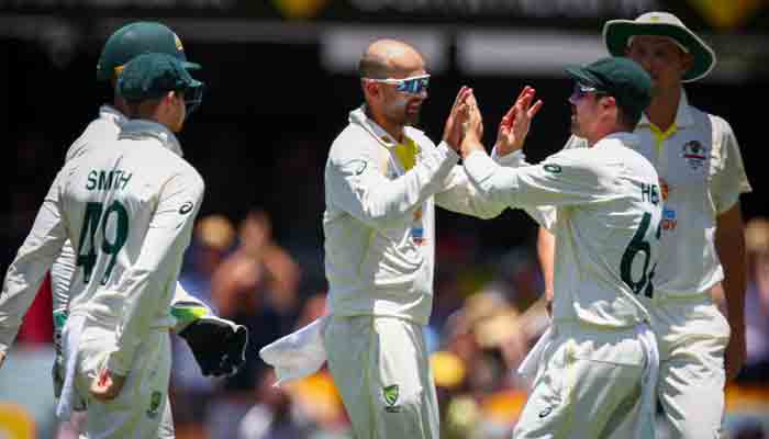 Australia´s Nathan Lyon (C) celebrates the wicket of England´s Ollie Pope during day four of the first Ashes cricket Test match between England and Australia at the Gabba in Brisbane on December 11, 2021. ---AFP