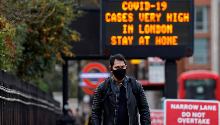 A pedestrian wearing a face mask or covering due to the Covid-19 pandemic, walks in central London on December 23, 2020. — AFP/File