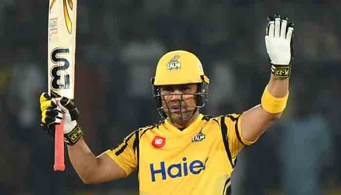 Test cricketer Kamran Akmal raises his bat to the crowd in this PSL file photo.