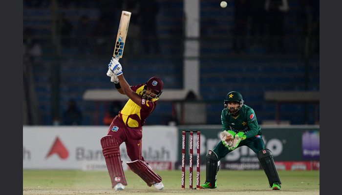West Indies captain Nicholas Pooran (L) plays a shot as Pakistan wicketkeeper Mohammad Rizwan watches during the third Twenty20 international cricket match between Pakistan and West Indies at the National Stadium in Karachi on December 16, 2021. — Photo by ASIF HASSAN/AFP