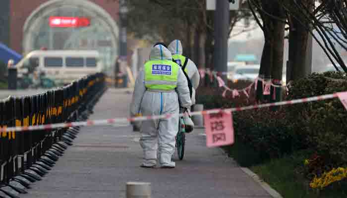 This photo taken on December 22, 2021 shows security guards walking in an area that is under restrictions following a recent coronavirus outbreak in Xi´an in China´s northern Shaanxi province. -AFP