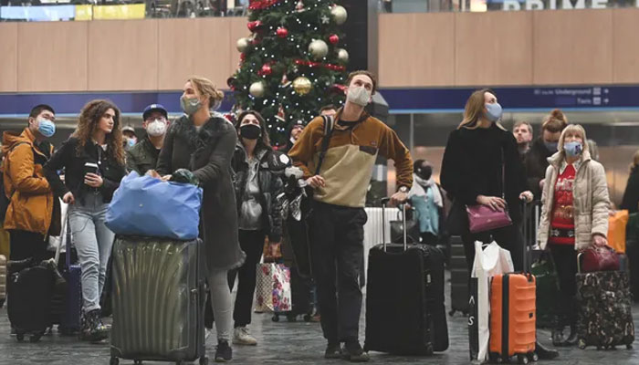 Travellers wait at Euston station in London on Christmas Eve as data showed one in 35 people in England had Covid last week. File photo