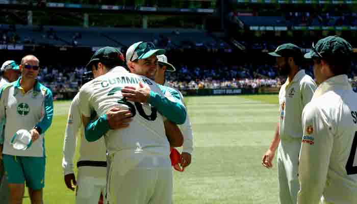 Australia´s captain Pat Cummins gives a hug to team´s coach Justin Langer after Australia won the match and retained the Ashes at the end of the third Ashes cricket Test match between Australia and England in Melbourne on December 28, 2021- AFP