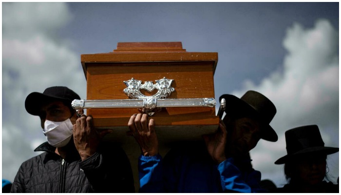 Men carry a coffin at a funeral in Peru. — AFP