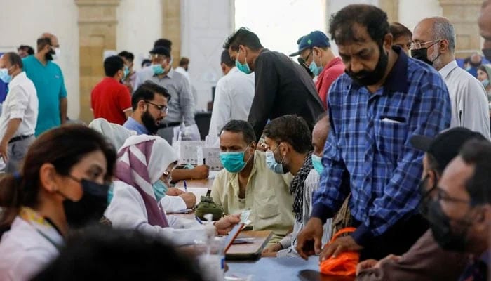 People gather to receive their coronavirus disease (COVID-19) vaccine doses, at a vaccination center in Karachi. Photo: file
