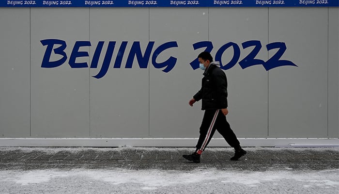 A Man Walks Past A Promotion For The 2022 Beijing Winter Olympic Games, At The Olympic Park, Two Weeks Before The Start Of The 2022 Beijing Winter Olympic Games, On A Snowy Day In Beijing On January 20, 2022. — Afp