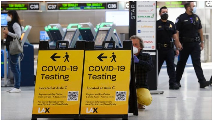 A traveller takes a photo of a Covid-19 testing sign at the Tom Bradley International Terminal (TBIT) amidst travel restrictions during the Covid-19 pandemic at Los Angeles International Airport (LAX) on February 4, 2021, in Los Angeles, California. — Patrick T. Fallon | AFP | Getty Images