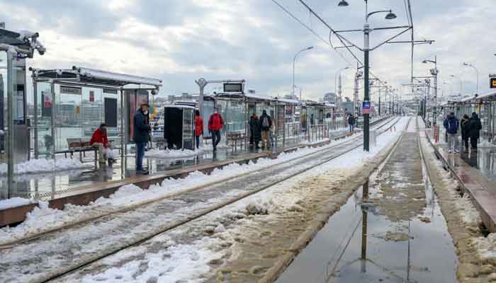 Commuters wait for tramway in Karakoy district of Istanbul on January 25, 2022 after a snowstorm. Istanbul is experiencing heavy snowfalls, with roads blocked, flights and intercity transportation canceled and thousands of vehicles stranded on majors roads. — AFP
