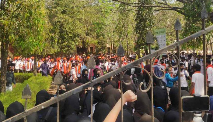 Saffron-scarves clad male students are chanting slogans against Muslim girls wearing hijabs. Photo: Twitter