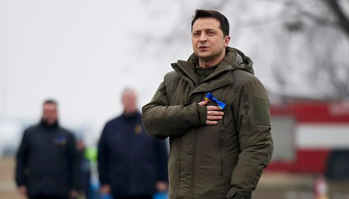 In this handout photo provided by the Ukrainian Presidential Press Office, Ukrainian President Volodymyr Zelenskyy listens to Ukrainian national anthem as he takes part in the celebration of the Day of the Unit at an international airport outside Kyiv, Ukraine, Wednesday, February 16, 2022. — Ukrainian Presidential Press Office