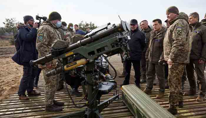 This handout photograph taken and released by the Ukrainian Defence Ministry on February 16, 2022, shows Ukrainian President Volodymyr Zelensky (2nd R) listening to explanations during a military drill outside the city of Rivne, northern Ukraine.-AFP