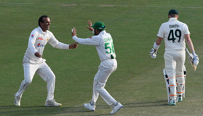 Pakistans Nauman Ali (L) celebrates with teammate captain Babar Azam (C) after the dismissal of Australias Steven Smith (R) during the fourth day play of the first Test cricket match between Pakistan and Australia at the Rawalpindi Cricket Stadium in Rawalpindi on March 7, 2022. — AFP