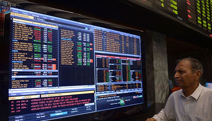 A person stanidng in front of a scren at the stock exchange. — AFP/File