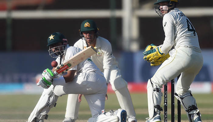 Pakistans captain Babar Azam (L) plays a shot as Australias wicketkeeper Alex Carey (R) watches during the fourth day of the second Test cricket match between Pakistan and Australia at the National Cricket Stadium in Karachi on March 15, 2022. — AFP