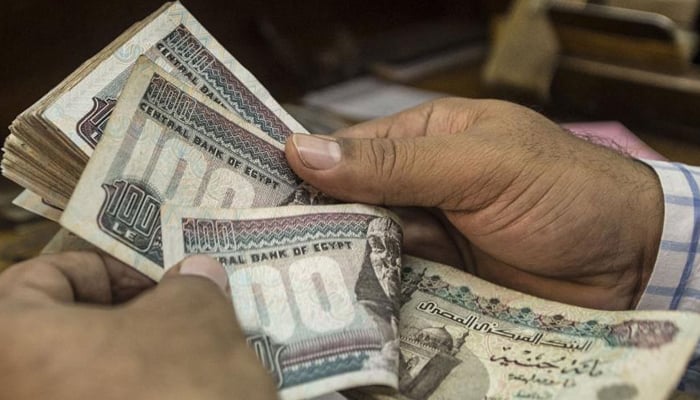 A man counts Egyptian pounds at a currency exchange shop in downtown Cairo, November 3, 2016. — AFP