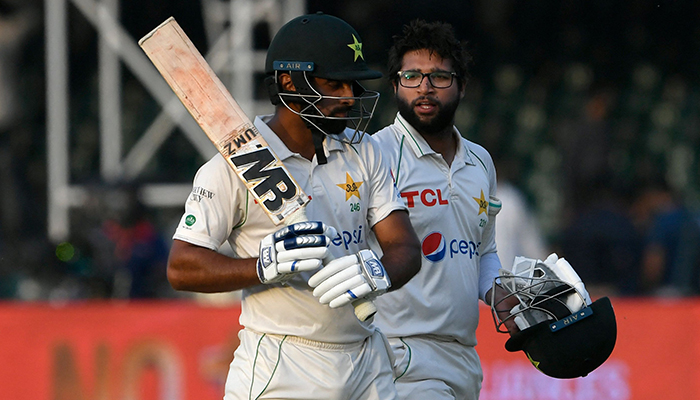 Pakistans Abdullah Shafique (L) and Imam-ul-Haq walk back to the pavilion at the end of the fourth day play of the third and final Test cricket match between Pakistan and Australia at the Gaddafi Cricket Stadium in Lahore on March 24, 2022. — AFP