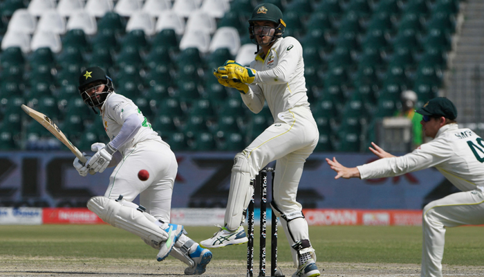 Pakistans Imam-ul-Haq (L) plays a shot during the fifth and last day of the third cricket Test match between Pakistan and Australia at the Gaddafi Cricket Stadium in Lahore on March 25, 2022. -AFP