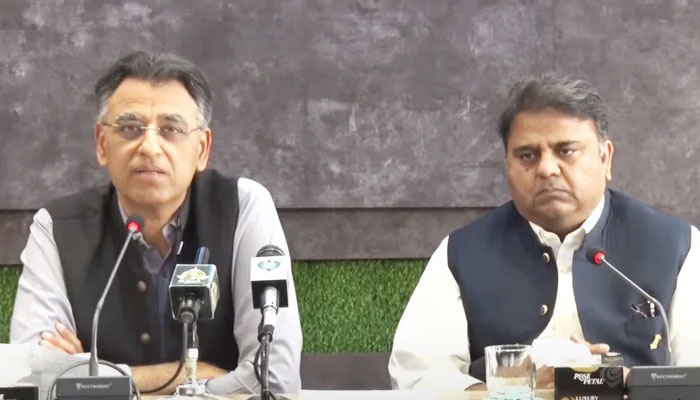 Federal Minister for Planning, Development, and Special Initiatives Asad Umar (L) addresses a press conference along with Information Minister Fawad Chaudhry (R) in Islamabad, on March 29, 2022. 1 YouTube/HumNewsLive