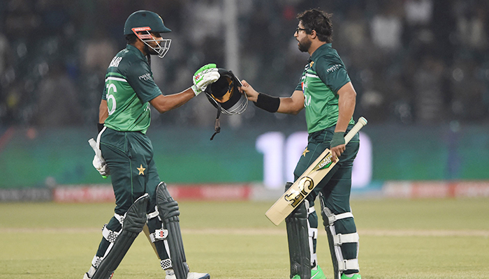 Pakistan's Imam-ul-Haq (R) celebrates with teammate Babar Azam (L) after scoring a century (100 runs) during the second one-day international (ODI) cricket match between Pakistan and Australia at the Gaddafi Cricket Stadium in Lahore on March 31, 2022. — AFP