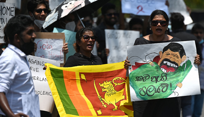 Protestors hold banners and placards during a demonstration against the surge in prices and shortage of fuel and other essential commodities in Colombo on April 4, 2022. — AFP