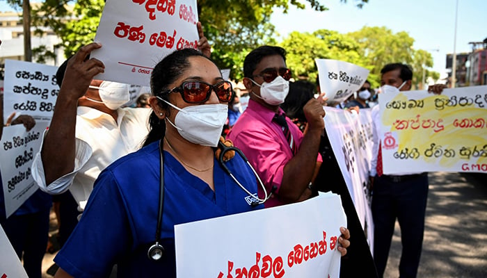 Members of the Government Medical Officers Association hold placards during a silent demonstration against Sri Lankas deepening economic crisis in Colombo on April 6, 2022. — AFP