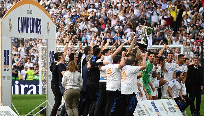 Real Madrids players celebrate with the Liga trophy at the end of the Spanish League football match between Real Madrid CF and RCD Espanyol at the Santiago Bernabeu stadium in Madrid on April 30, 2022. — AFP