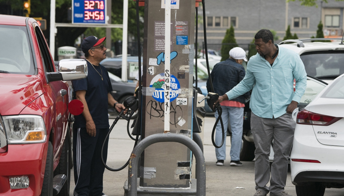 Customers pump gasoline into their cars at a gas station in the Bronx, on June 1, 2018, in New York. — AFP