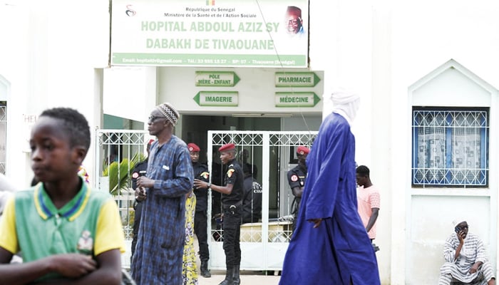 Visitors stand in front of the Mame Abdoul Aziz Sy Dabakh Hospital, where eleven babies died following an electrical fault, in Tivaouane, on May 26, 2022. — AFP