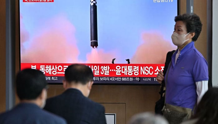People watch a television screen showing a news broadcast with file footage of a North Korean missile test, at a railway station in Seoul on May 25, 2022, after North Korea fired three ballistic missiles according to South Koreas military. Photo: AFP/File