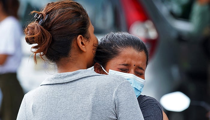 Family members and relatives of passengers onboard the Twin Otter aircraft operated by Tara Air, weep outside the airport in Pokhara on May 29, 2022. — AFP