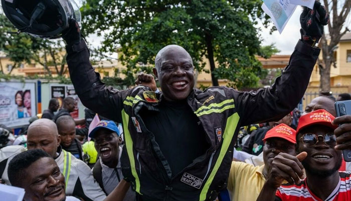Kunle Adeyanju (C) celebrates with supporters after completing a 41-day trip from London to Lagos, by motorbike, to raise funds and awareness against polio. Photo: AFP