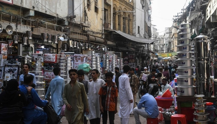 People shop at a market in Karachi in this file photo. — AFP