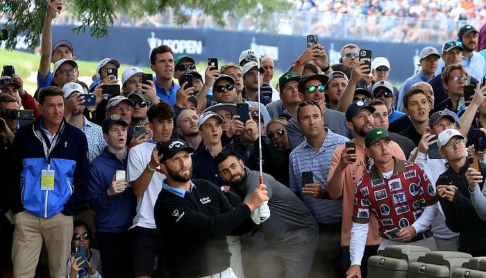 Defending champion Jon Rahm of Spain plays his third shot from a spectator path on the eighth hole in Saturdays third round of the US Open. Photo: AFP