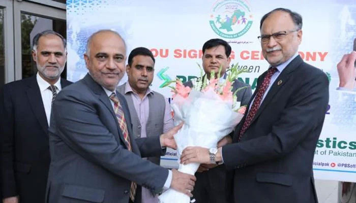 Federal Minister for Planning, Development and Special Initiatives Ahsan Iqbal receives a bouquet at MoU signing ceremony. — APP