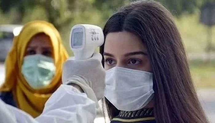Un paramedico controlla la temperatura corporea di una donna con una pistola termica.  Foto: file Geo.tv/