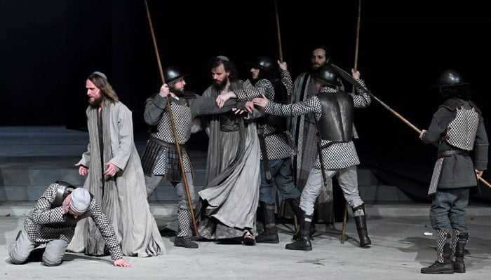 The plays themes of violence, poverty and sickness are reflected in todays world through the war in Ukraine and Covid, says Frederik Mayet (2ndL) who plays Jesus. Photo: AFP/File